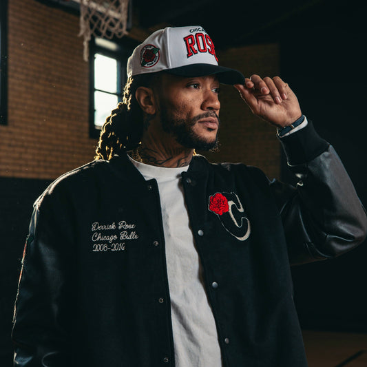 Man wearing a 'Chicago's Rose' cap and black varsity jacket with a red rose emblem.