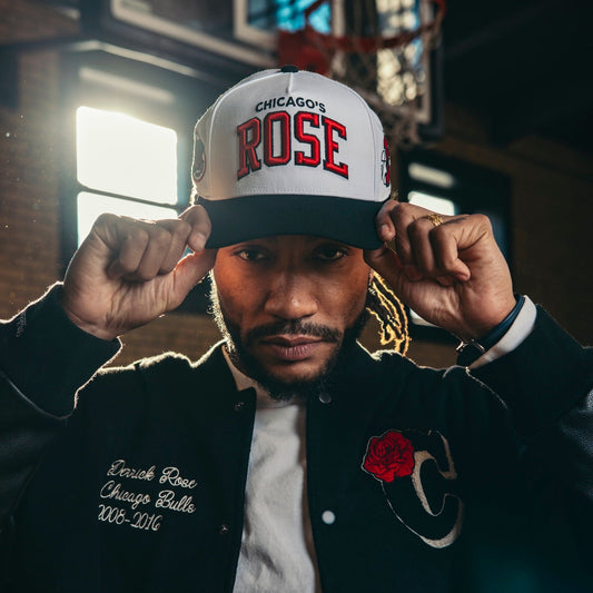 Man wearing a 'Chicago's Rose' cap and black varsity jacket with a red rose emblem.